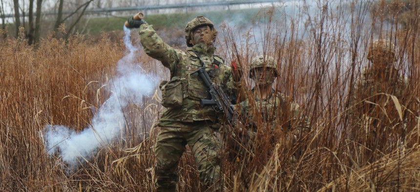 A U.S. Paratrooper assigned to the 3rd Brigade Combat Team, 82nd Airborne Division throws a smoke grenade to provide concealment for a breach team, as part of a joint training exercise with the Polish Army near Zamosc, Poland, March 31.