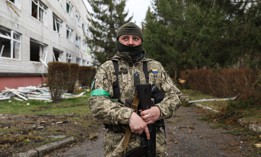 A Ukrainian soldier stands watch by a building severely damaged in attacks by Russian forces in the Makariv region near Kyiv, Ukraine, on April 10, 2022.