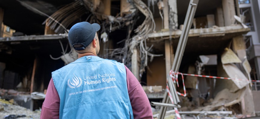 A United Nations Human Rights monitor looks over damage the morning after a missile strike in the Shevchenkivskyi district on April 29, 2022 in Kyiv, Ukraine. 