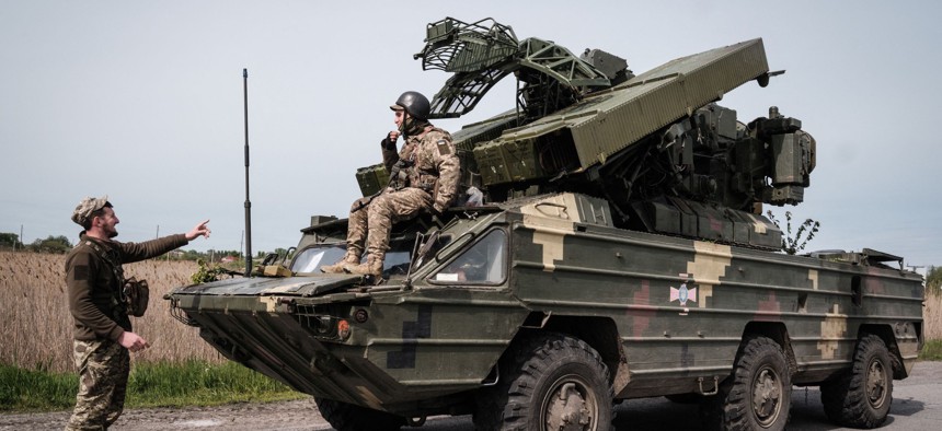 Ukrainian soldiers gesture around their anti-aircraft missile system near Sloviansk in eastern Ukraine, on May 11, 2022.