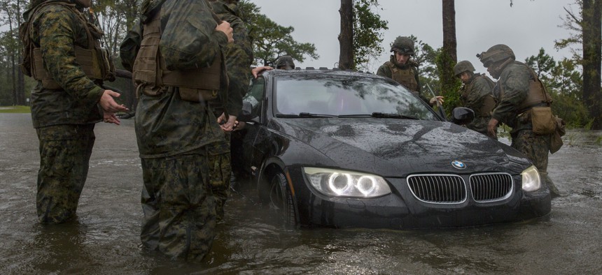 Marines with Marine Corps Base Camp Lejeune help push a car out of a flooded area during Hurricane Florence, Sept. 15, 2018.