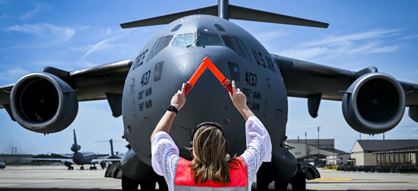 Julie Camerer, wife of U.S. Air Force Maj. Gen. Mark Camerer, U.S. Air Force Expeditionary Center, commander, signals the landing of her husband's fini flight return on May 18, 2022, at Joint Base McGuire-Dix-Lakehurst, N.J. 