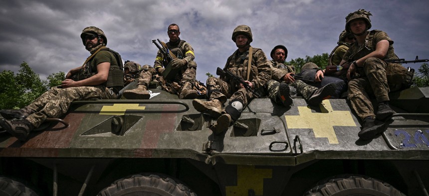 Ukrainian troops sit on an armoured vehicle as they move back from the front line near the city of Sloviansk in the eastern Ukrainian region of Donbas on June 1, 2022.