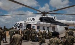 Members of the Uganda People's Defense Force serving in the African Union Mission in Somalia load an United Nations helicopter in 2016 in Barawe, Somalia. 