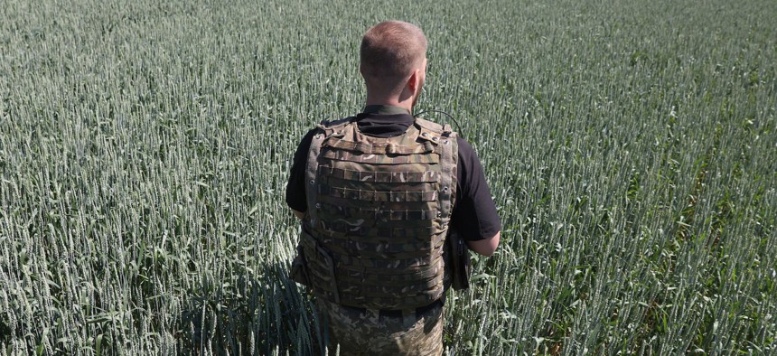 A Ukrainian serviceman attends at wheat field on the front line near the city of Soledar, Donetsk region, on June 10, 2022.
