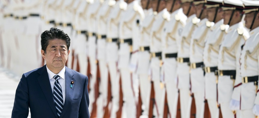 Then-Japanese Prime Minister Shinzo Abe inspects an honor guard ahead of a Self Defense Forces (SDF) senior officers' meeting at the Ministry of Defense on September 17, 2019 in Tokyo, Japan.