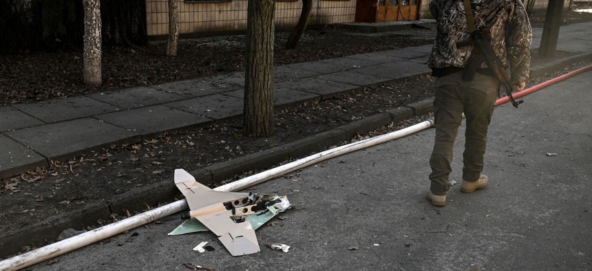 A Ukranian serviceman stands next to a downed Russian drone in the area of a research institute, part of Ukraine's National Academy of Science, after a strike, in northwestern Kyiv, on March 22, 2022.