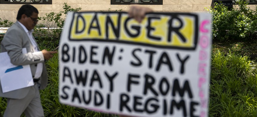 A human rights activist holds a sign protesting Saudi Arabia outside the Embassy of the Kingdom of Saudi Arabia on June 15, 2022, in Washington, DC.