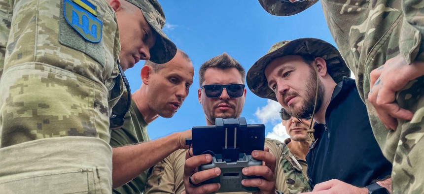Ukrainian servicemen look at a drone controller during a practice session on the outskirts of Kyiv, on July 14, 2022. 