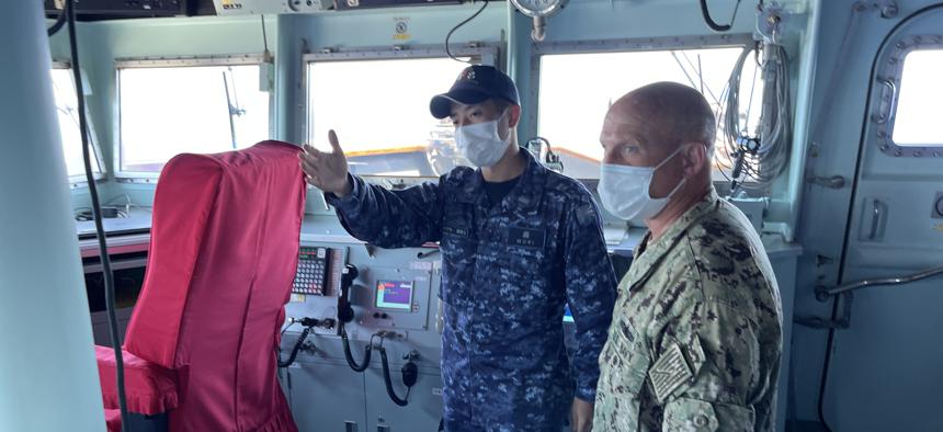 Chief of Naval Operations Adm. Mike Gilday learns more about the bridge operations aboard the Japanese helicopter carrier JS Izumo Friday while it was operating in the Pacific Ocean during RIMPAC 2022. Gilday was visiting the ship to learn about the ship and their work during the exercise.