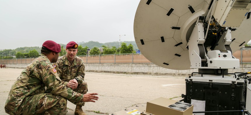 Maj. Ryan Collins (right), the 1st Special Forces Group (Airborne) signal officer, and Staff Sgt. Robert Carter, a satellite communications operator, troubleshoot a satellite antenna during a training exercise, April 28, 2018.