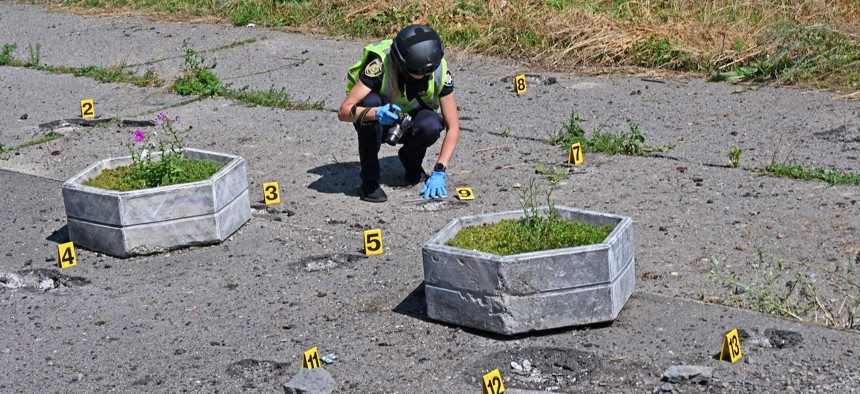 A deminer checks the site of a cluster munition fall after a rocket attack on a residential area in northern Kharkiv, which killed one local resident and injured another, on August 8, 2022.