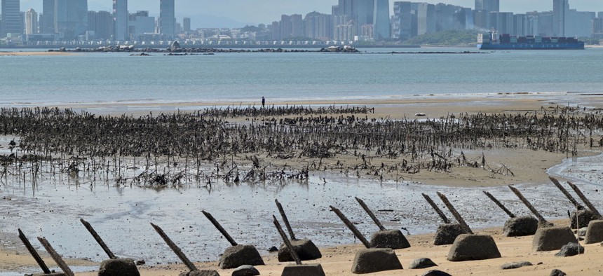 The Xiamen city skyline on the Chinese mainland is seen past anti-landing spikes placed along the coast of Lieyu islet on Taiwan's Kinmen islands, which lie just 3.2 kms (two miles) from the mainland China coast, on August 10, 2022.
