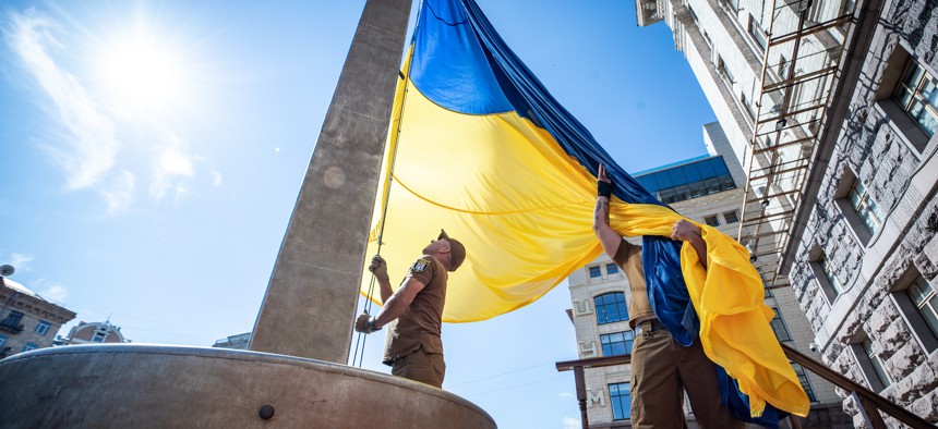 Ukrainian military members are seen during a flag raising ceremony for the State Flag of Ukraine that takes place near City Hall on July 28, 2022 in Kyiv, Ukraine.