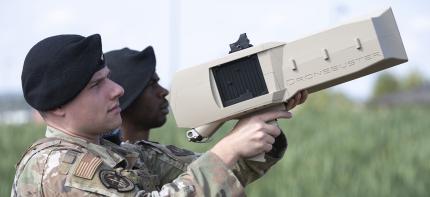 Airman 1st Class Nathan Sands, front, 52nd Security Forces Squadron patrolman, and Tech. Sgt. Nicholas Brown, 52nd SFS flight sergeant, demonstrate the Dronebuster 3B at Spangdahlem Air Base, Germany, Sept. 1, 2022. 
