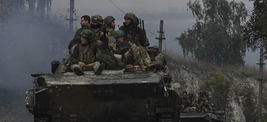 Ukrainian soldiers sit on infantry fighting vehicles as they drive near Izyum, eastern Ukraine on September 16, 2022.