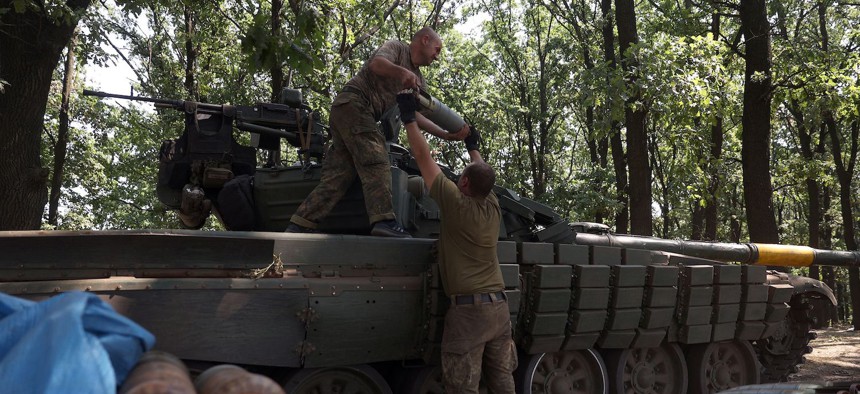 Ukrainian tankers load munition shells onto their tank at the front line in the Donetsk region on August 19, 2022.