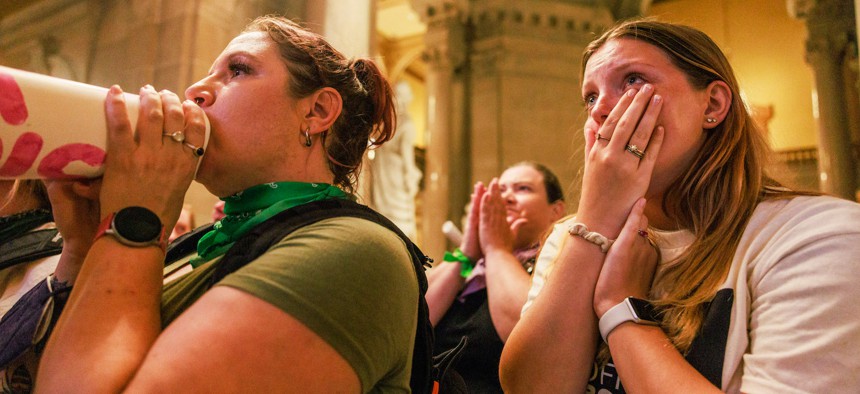 Abortion rights activists react after the Indiana Senate votes to ban abortion, inside the Indiana State house during a special session in Indianapolis.