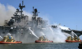 Sailors and federal firefighters combat a fire onboard the USS Bonhomme Richard (LHD 6) at Naval Base San Diego, California, July 12, 2020.