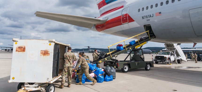 U.S. Air Force airmen assigned to the 721st Aerial Port Squadron load luggage onto an American Airlines aircraft during Operation Allies Refuge at Ramstein Air Base, Germany, Aug. 27, 2021.