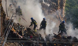 Ukrainian rescuers work to clear the rubble of a residential building destroyed by Russian kamikaze drones in downtown Kyiv on October 17, 2022.