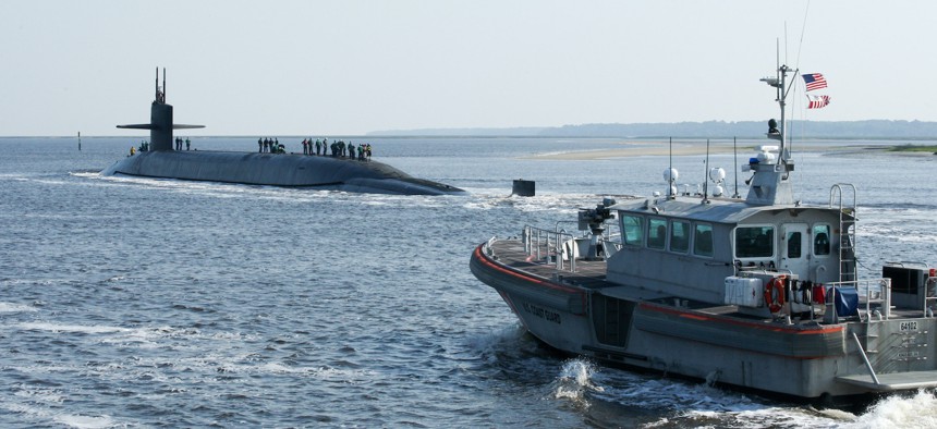 A U.S Coast Guard patrol boat, right, escorts the ballistic missile submarine USS Alaska (SSBN 732) as the submarine returns to Naval Submarine Base Kings Bay, Ga., May 22, 2014.