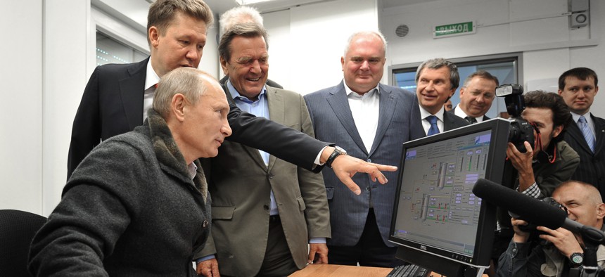 Russian Prime Minister Vladimir Putin (L),Gazprom Chief Executive Officer Alexei Miller (2nd L) and former German chancellor Gerhard Schroeder (3rd L) look at a screen as they attend the inauguration of the Nord Stream Project information mount at the gas compressor station "Portovaya" outside Vyborg, September 6, 2011