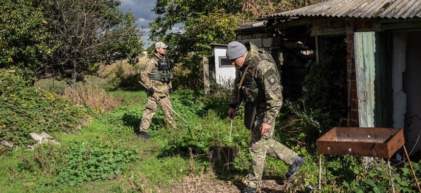 National guard special operations soldiers Alexander Lemyshka (R) and Borodai Anatoly, check for anti-personnel mines and booby traps in a compound previously used as a residence by the head of Russian occupying forces as they make it safe to be searched for evidence of war crimes by police investigators, on October 14, 2022 in Vyshneve, Kharkiv oblast, Ukraine. 