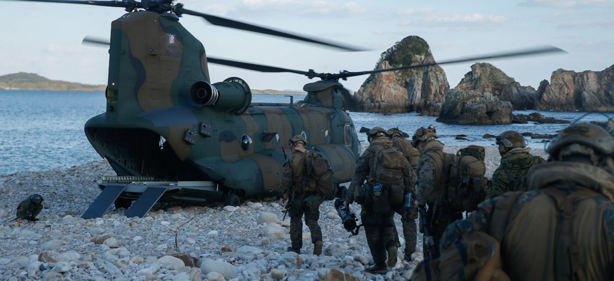 U.S. Marines with 1st Battalion, 2d Marines and members of the Japan Self-Defense Force Amphibious Rapid Deployment Brigade prepare to load onto a Japan Self Defense Force CH-47JA Chinook helicopter during Keen Sword 23 at Tsutara, Japan, Nov. 16, 2022.