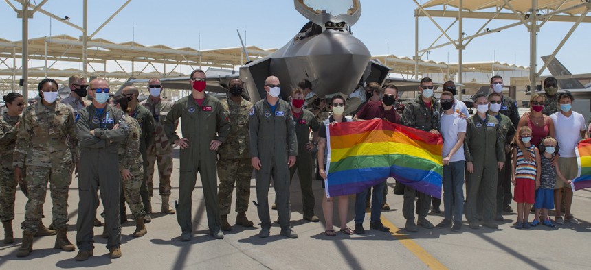 Airmen and family members pose on the flight line at Luke Air Force Base, Ariz., after a Pride Month flyby on June 26, 2020.