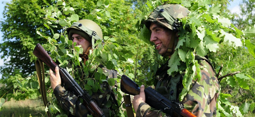 Ukrainian Soldiers prepare to ambush soldiers from the U.S., Ukraine, Romania and Bulgaria has they conduct reacting to contact training as part of their situational training at the multi-national exercise Rapid Trident 2015 at the International Peacekeeping and Security Center near Yavoriv, Ukraine, July 21, 2015.
