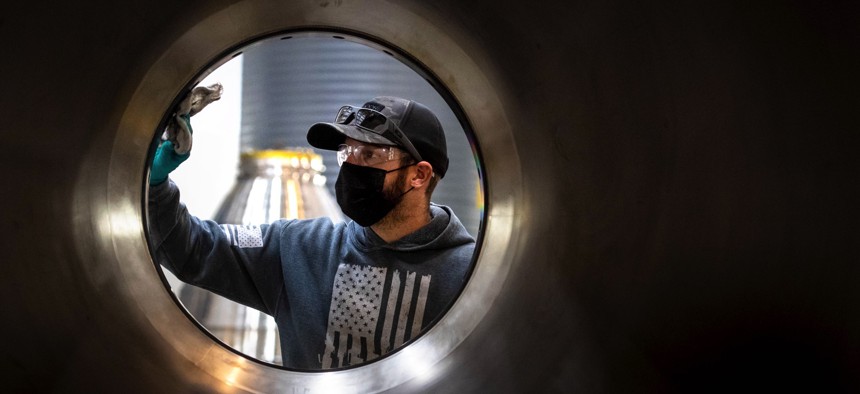 Chase Wallace, a metal fitter, dusts off an RS-25 rocket engine nozzle in preparation for brazing at Aerojet Rocketdyne in Canoga Park, California.