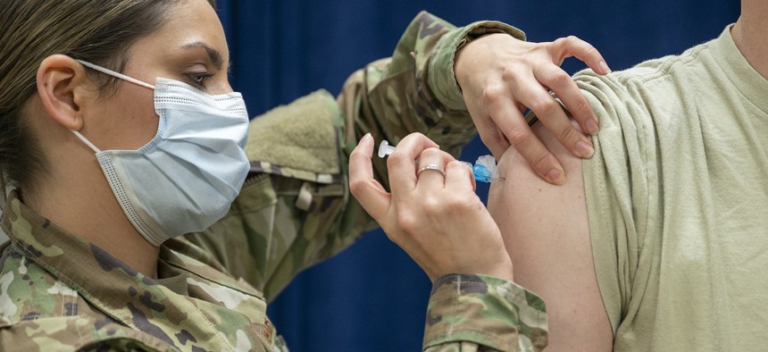 Technical Sgt. Nicole Rodriguez, a medical technician with the 920th Aeromedical Staging Squadron, administers a COVID-19 booster shot Jan. 09, 2022, at MacDill Air Force Base, Fla. 