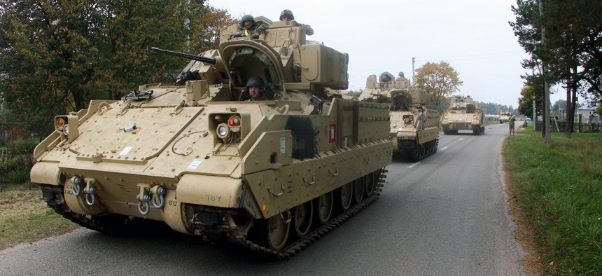 Members of the US Army 1st Brigade, 1st Cavalry Division, drive Bradley Fighting Vehicles from the railway station near the Rukla military base in Lithuania, on October 4, 2014.