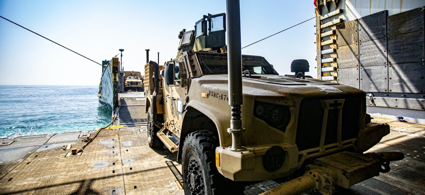 A joint light tactical vehicle attached to the 24th Marine Expeditionary Unit (MEU) is transferred from dock landing ship USS Carter Hall (LSD 50) to Landing Craft Utility 1661 during vehicle and equipment loading operations in the Arabian Gulf, July 16, 2021.