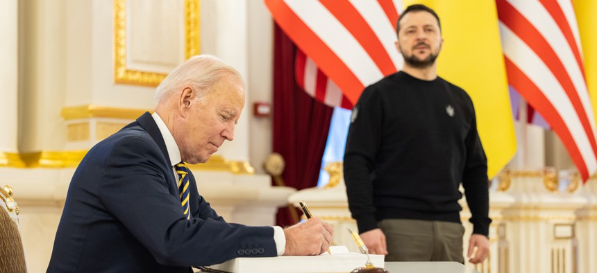 In this handout photo issued by the Ukrainian Presidential Press Office, U.S. President Joe Biden signs the guest book during a meeting with Ukrainian President Volodymyr Zelensky at the Ukrainian presidential palace on February 20, 2023 in Kyiv, Ukraine.