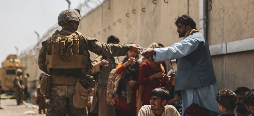 A Marine with the 24th Marine Expeditionary unit (MEU) passes out water to evacuees during the evacuation at Hamid Karzai International Airport during the evacuation on August 21, 2021 in Kabul, Afghanistan. 