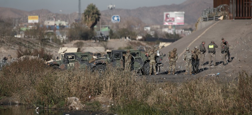 National Guard troops and state troopers line the bank of the border on American side in Ciudad Juarez, Mexico, on December 20, 2022.