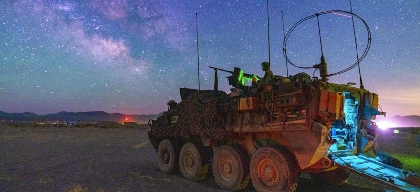 Army Sgt. Justin Covert mans an M1A2 .50-caliber machine gun on a Stryker vehicle during training at Fort Irwin, Calif., as the Milky Way galactic center is visible overhead, May 24, 2022.