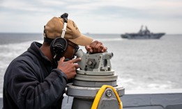 A sailor takes a bearing aboard the San Antonio-class amphibious transport dock ship USS Arlington (LPD 24) during a multinational exercise in the Baltic Sea on Aug. 3, 2022.