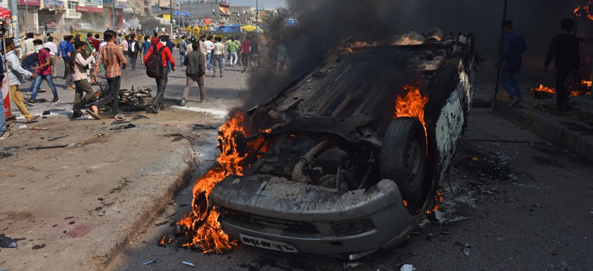 A car burns on February 23, 2020, during riots in New Delhi, India.