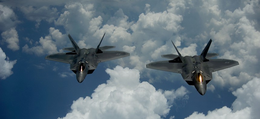 A pair of 1st Fighter Wing's F-22 Raptors from Joint Base Langley-Eustis, Va., pulls away and flies behind a KC-135 Stratotanker with the 756th Air Refueling Squadron, Joint Base Andrews Naval Air Facility, Md., after receiving fuel off the east coast on July 10, 2012. 