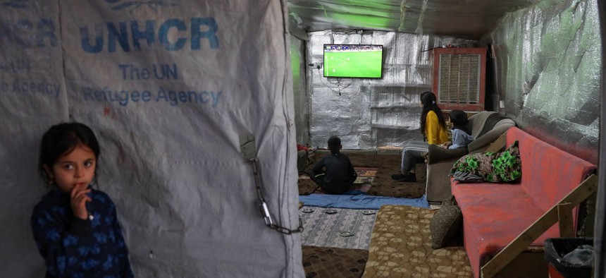 Displaced Iraqi children from the Yazidi community watch a football match on televison inside a tent at a camp for internally displaced persons (IDP) in Khanke, a few kilometres from the Turkish border in Iraq's Dohuk province, on January 20, 2023. 
