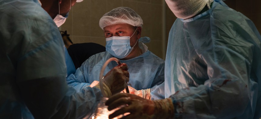 Vascular surgeon Dr. Dmytro, left, works with surgeon Dr. Vitaliy and Dr. Mykola on a patient with abdominal injuries in a hospital where military are treated on October 7, 2022, in Donetsk District, Ukraine. 