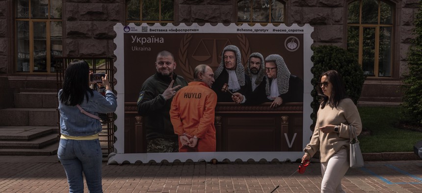 In downtown Kyiv in May 2023, a poster depicts Russian President Vladimir Putin appearing in front of judges of the International Court of Justice in The Hague. 