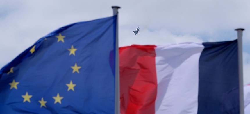 Lockheed Martin F-35A Lightning II performing an aerial over the Le Bourget Airport is seen past an European Union flag and a French flag on the first public day of the 52nd International Paris Air Show on June 23, 2017, in Paris, France. 