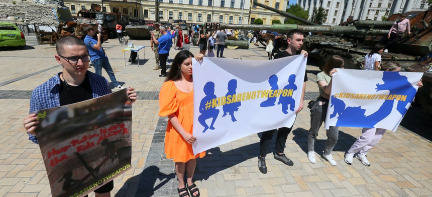 Ukrainians hold placards in Kyiv, Ukraine, June 4, 2023, at an event dedicated to remembering children who died as a result of the Russian invasion of Ukraine. 