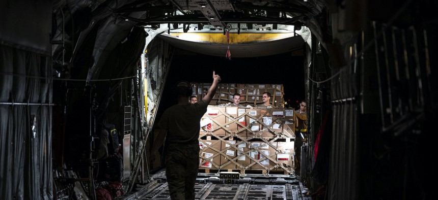 Airmen from the 436th Aerial Port Squadron assist in loading aircraft engine cargo onto a C-130J Super Hercules bound for Africa during a foreign military sales mission at Dover Air Force Base, Delaware, June 24, 2022. 