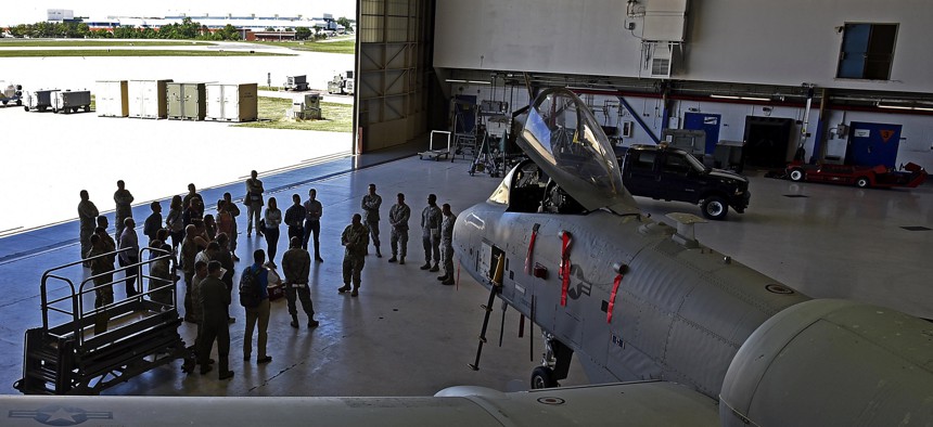 Members of the Office of the Cost Assessment and Program Evaluation listen to a briefing in the A-10 maintenance hangar at Warfield Air National Guard Base, Md., in 2017.