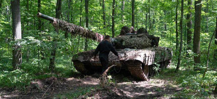 A Ukrainian serviceman of the 3rd Independent Tank Iron Brigade walks in front of a tank at a position near the front line in Kharkiv region, on June 15, 2023.